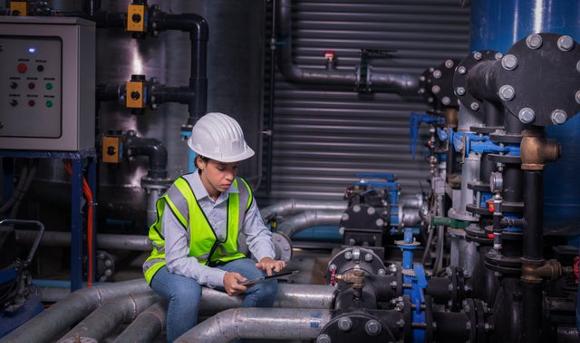 Engineering recruitment - controls and automation. Female engineer working on pipe system.